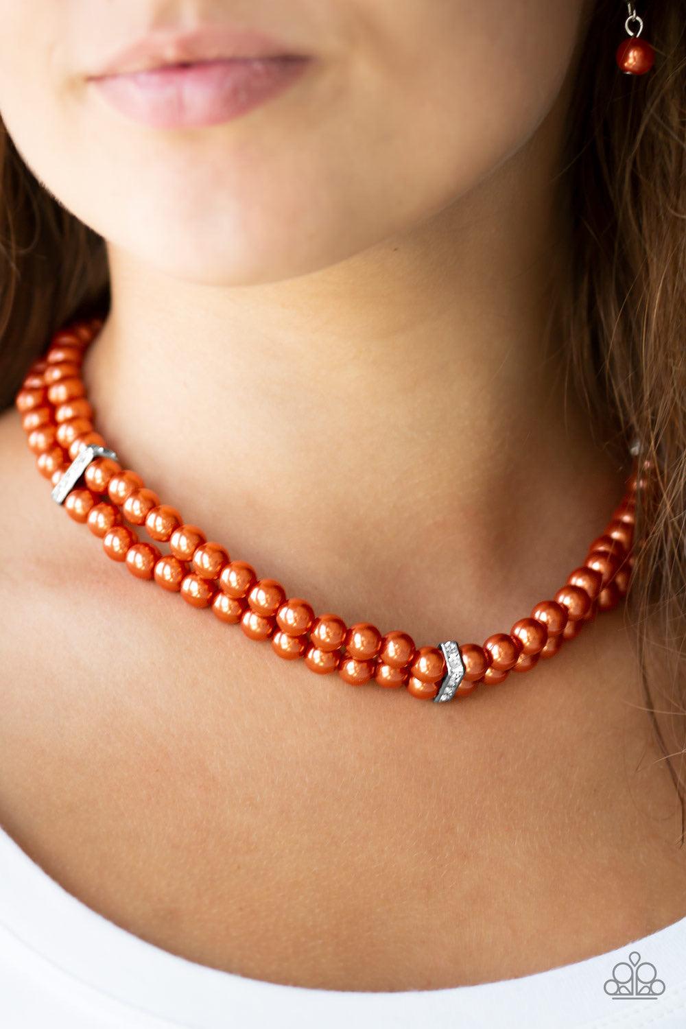 Paparazzi Accessories Put On Your Party Dress - Orange Pinched between white rhinestone encrusted frames, strands of classic orange pearls layer below the collar for a timeless look. Features an adjustable clasp closure. Jewelry