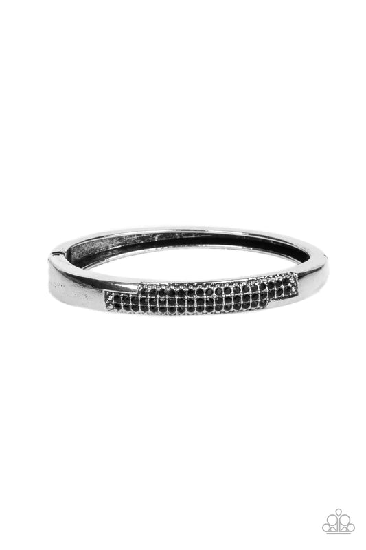 Paparazzi Accessories Chart-Topping Twinkle - Black The front of a silver frame is chiseled away, revealing two rows of glitzy black rhinestones across the center of a gritty bangle-like bracelet. Features a hinged closure. Sold as one individual bracelet