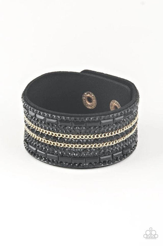 Paparazzi Accessories Rebel Radiance - Black Featuring classic round and edgy emerald style cuts, glittery black rhinestones and glistening gold chains are encrusted along bands of black suede for a sassy look. Features an adjustable snap closure. Jewelry