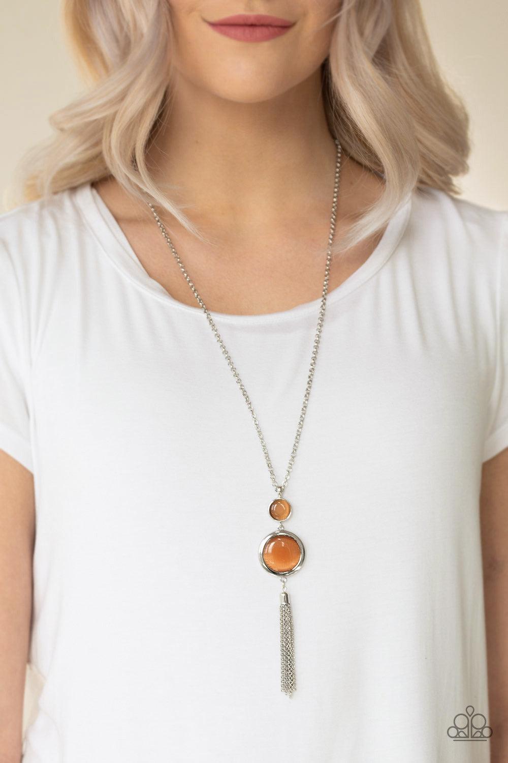 Paparazzi Accessories Have Some Common SENSE! - Orange Swinging from the bottom of a glistening silver chain, glowing stacked moonstone pendants give way to a shimmery silver tassel for a refined look. Features an adjustable clasp closure. Sold as one ind