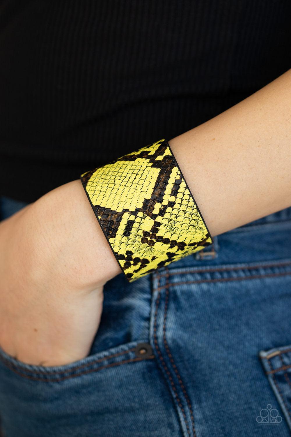 Paparazzi Accessories The Rest Is HISS-Tory - Yellow Featuring vibrant yellow and black python print, a thick black leather band wraps around the wrist for a wild fashion. Features an adjustable snap closure. Jewelry