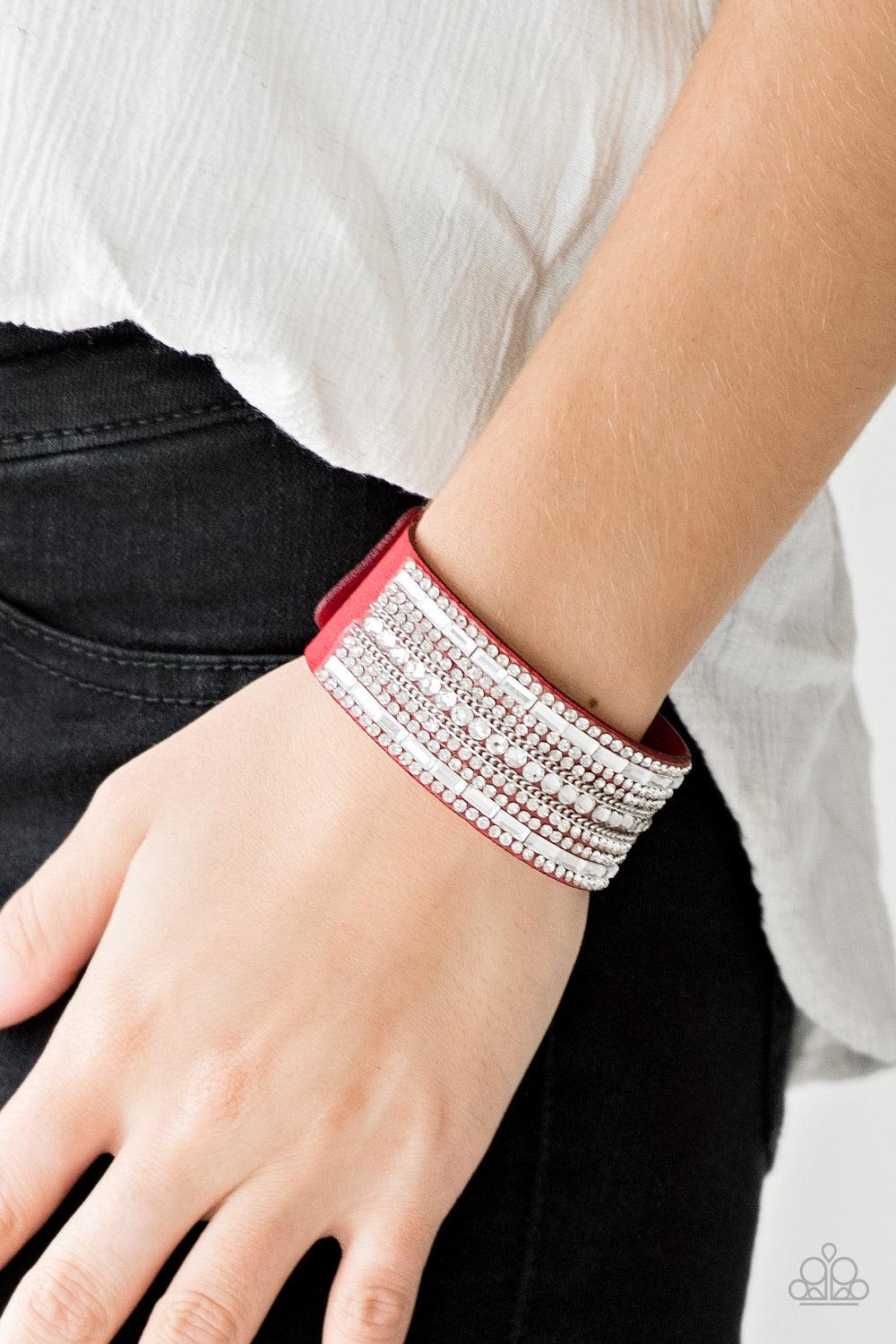 Paparazzi Accessories Rebel Radiance - Red Featuring classic round and edgy emerald style cuts, glittery white rhinestones and glistening silver chains are encrusted along bands of red suede for a sassy look. Features an adjustable snap closure. Sold as o