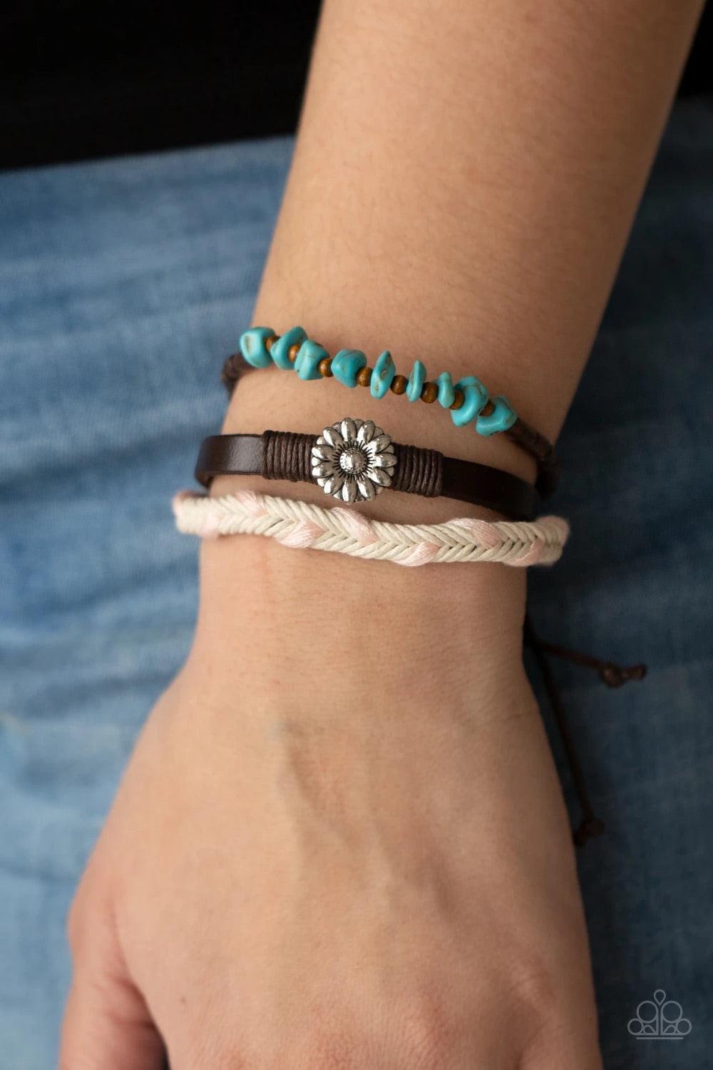 Paparazzi Accessories Terrain Trend - Pink Featuring a silver floral centerpiece, mismatched strands of turquoise stones and wooden beads, brown leather, and braided pink and white cording layers across the wrist for a seasonal flair. Features an adjustab