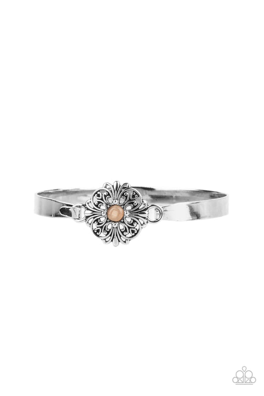 Paparazzi Accessories Whimsically Welcoming - Orange Dotted with a dainty orange cat's eye stone center, a silver floral filigree frame hinges to the center of a dainty silver cuff-like bangle for a whimsical finish. Features a hinged closure. Sold as one