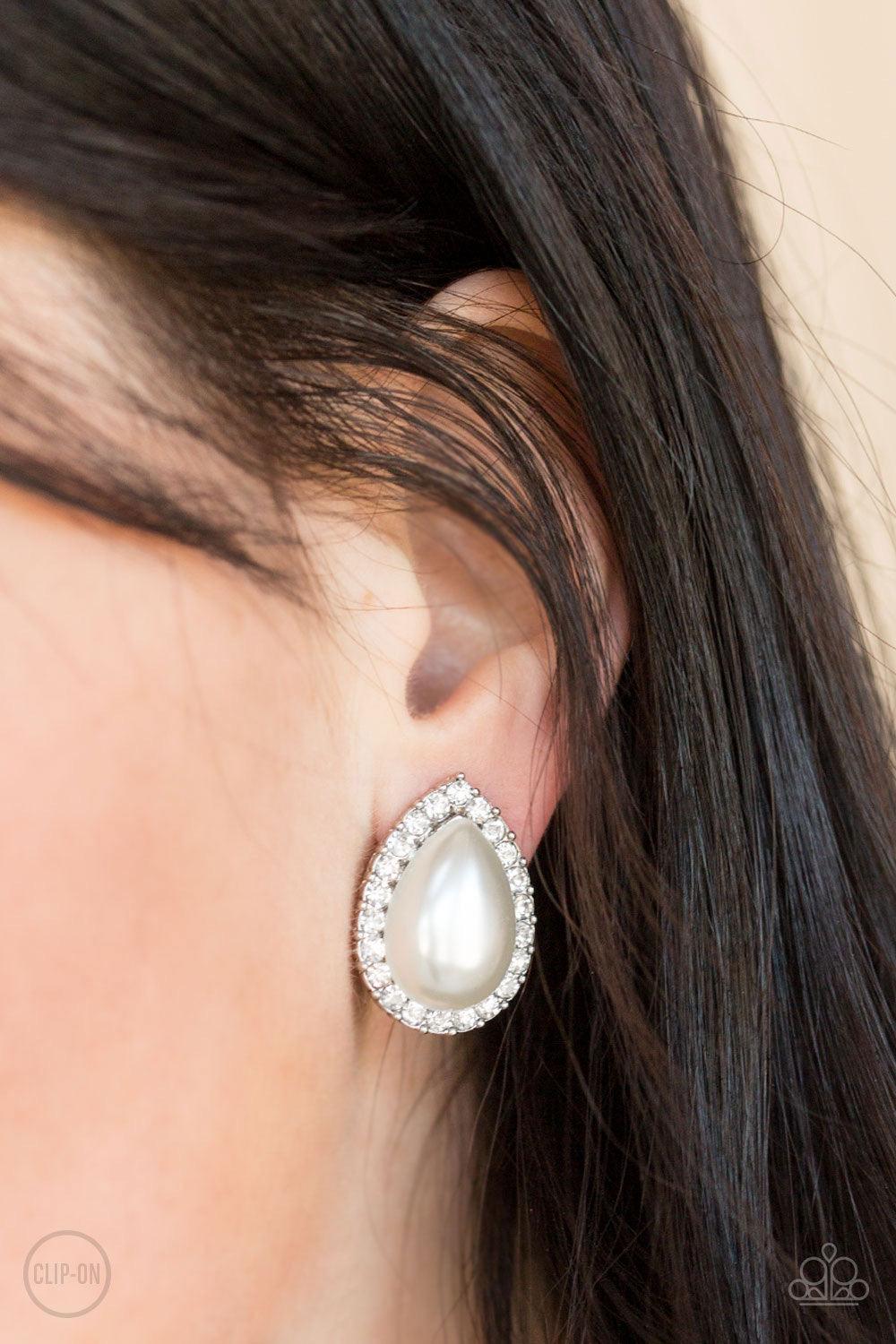 Paparazzi Accessories Old Hollywood Opulence - White *Clip-On A ring of glassy white rhinestones spins around a pearly teardrop bead center, creating a timeless frame. Earring attaches to a standard clip-on earring. Sold as one pair of clip-on earrings. J