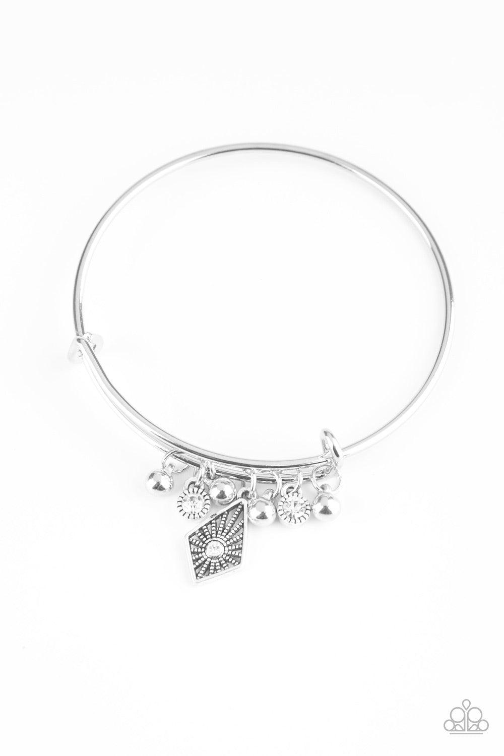 Paparazzi Accessories Treasure Charms - White A collection of shimmery silver beads and glittery white rhinestone accents slide along a sleek bar fitting, creating whimsical charms as they glide along the dainty silver bangle. Sold as one individual brace