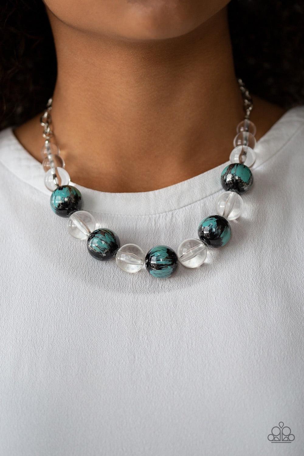 Paparazzi Accessories Torrid Tide - Blue A collection of shiny black and glassy clear beads are threaded along an invisible wire below the collar. The black beads are splashed in hints of refreshing blue and shiny metallic paint for a colorful finish. Fea