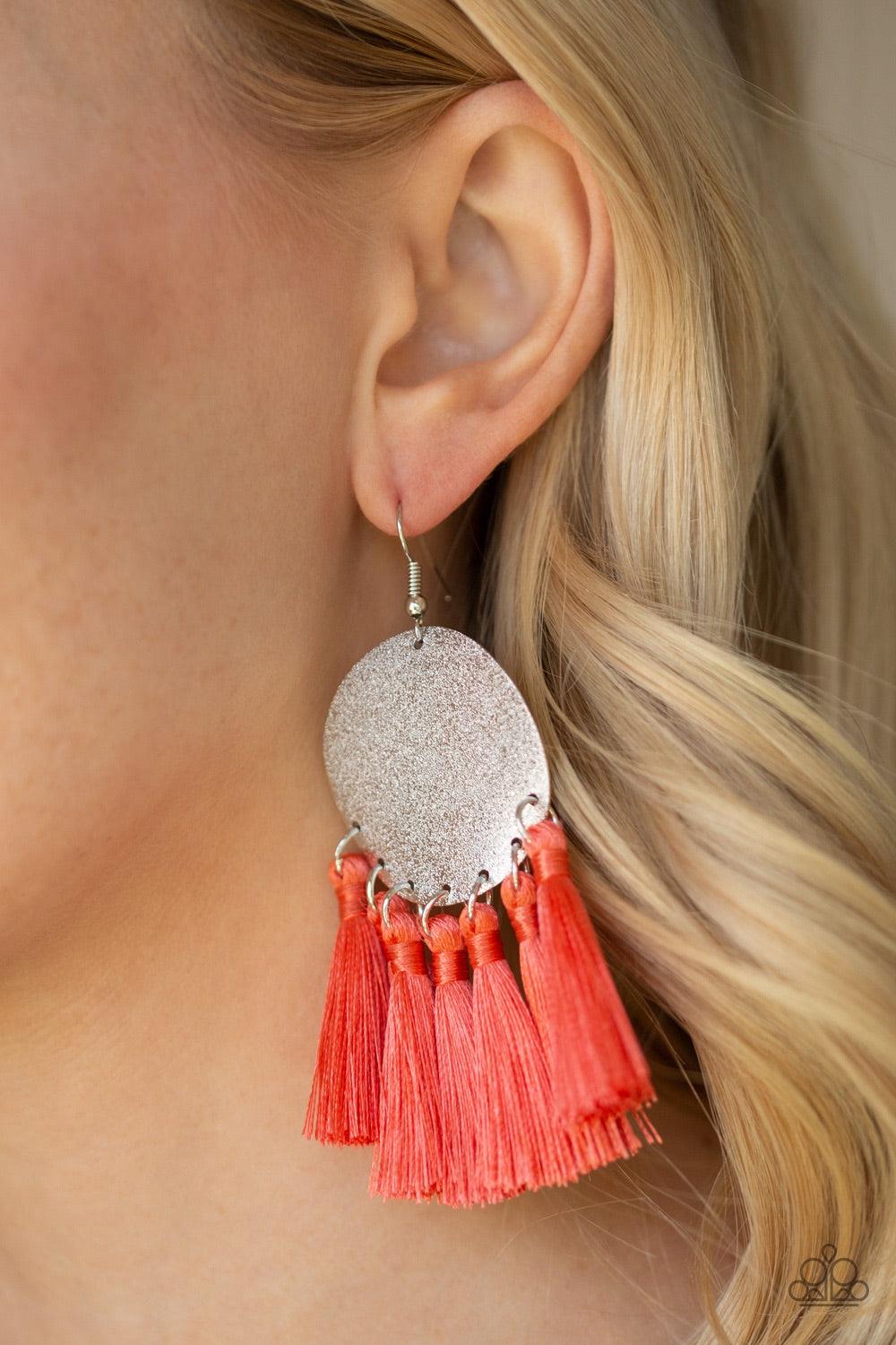 Paparazzi Accessories Tassel Tribute - Orange A fringe of shiny coral threaded tassels swing from the bottom of a warped silver disc brushed in an incandescent metallic shimmer for a whimsical flair. Earring attaches to a standard fishhook fitting. Jewelr