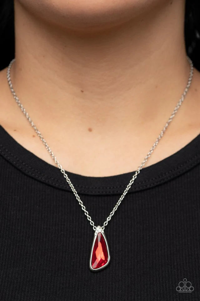 Paparazzi Accessories Envious Extravagance - Red An asymmetrical red gem is pressed into a shiny silver frame dusted in glassy white rhinestones, resulting in a refined pendant at the bottom of a dainty silver chain. Features an adjustable clasp closure.
