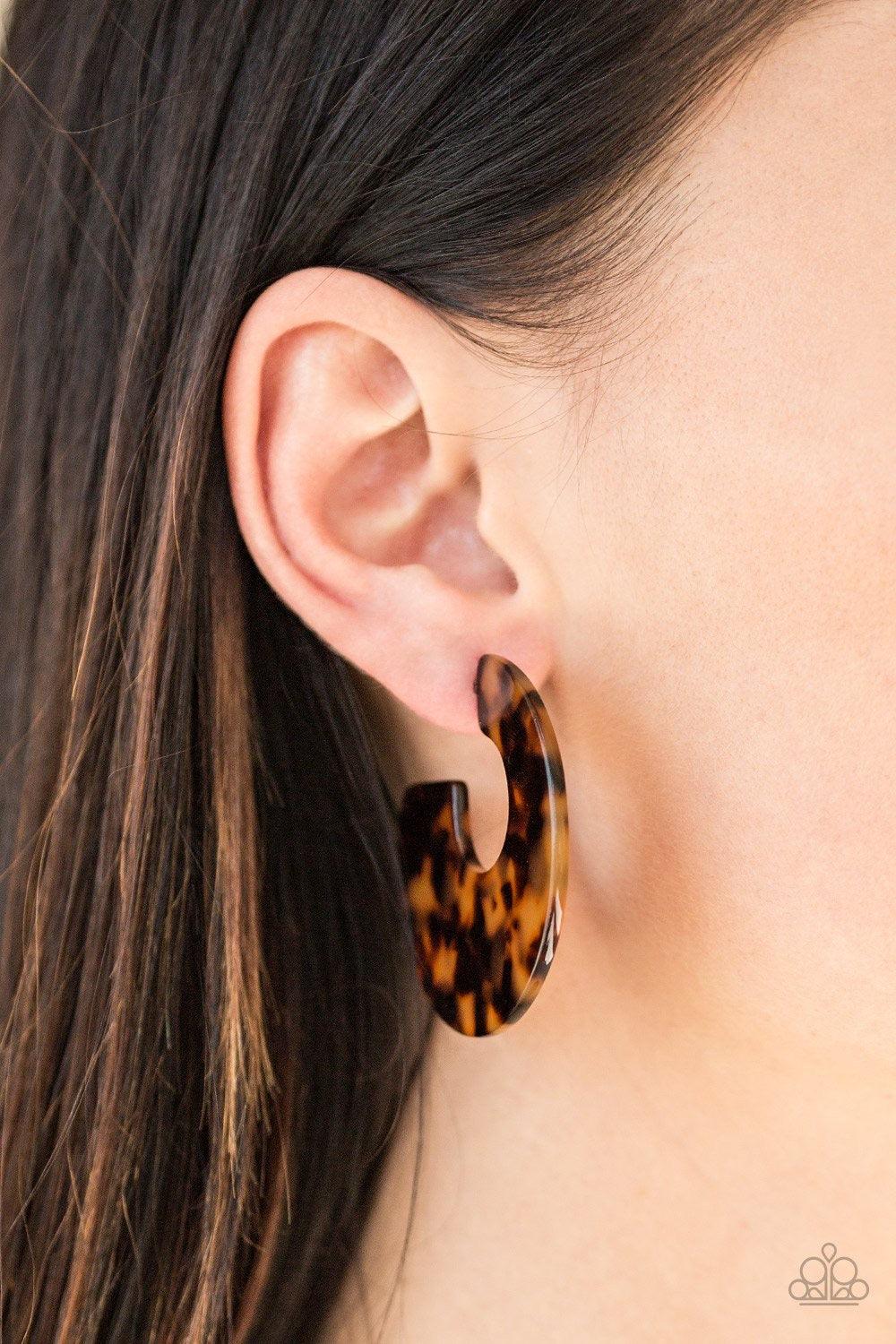 Paparazzi Accessories Tropically Torrid - Brown Brushed in a colorful faux marble finish, a flat brown hoop curls around the ear for a retro look. Earring attaches to a standard post fitting. Hoop measures 2" in diameter. Sold as one pair of hoop earrings