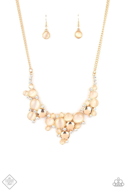 Paparazzi Accessories Fairytale Affair - Gold A bubbly collection of champagne cat's eye stones, glassy white rhinestones, and glistening gold discs delicately coalesces into enchanting frames below the collar that link into a whimsical centerpiece. Featu