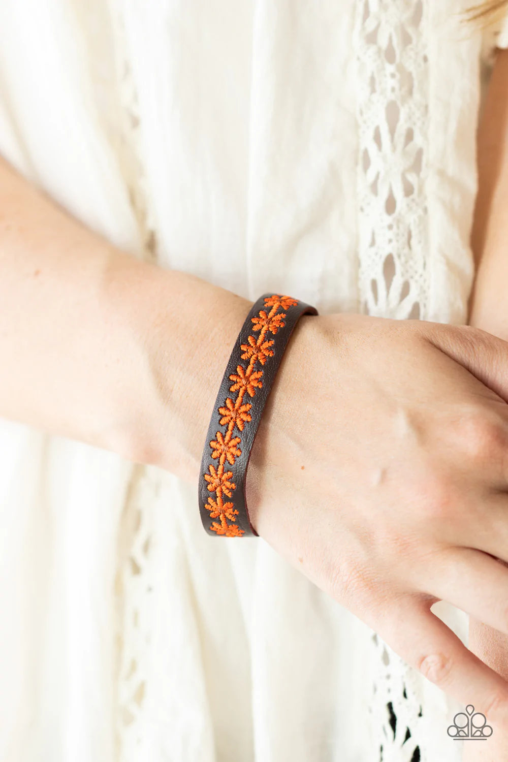 Paparazzi Accessories Wildflower Wayfarer - Orange Featuring dainty brown centers, a refreshing row of orange flowers is stitched across the front of a skinny brown leather band for a seasonal look. Features an adjustable snap closure. Sold as one individ