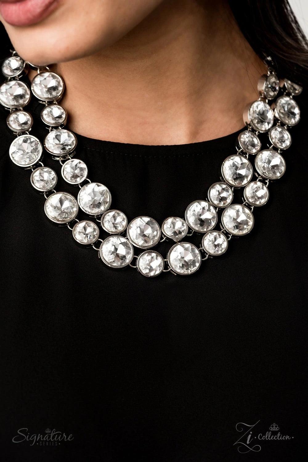 Paparazzi Accessories The Natasha Two rows of dramatically oversized rhinestones sparkle blindingly along the collar. The alternating sizes of the gems give this showstopper some exaggerated depth and dazzle. Features an adjustable clasp closure. 2019 ZiC