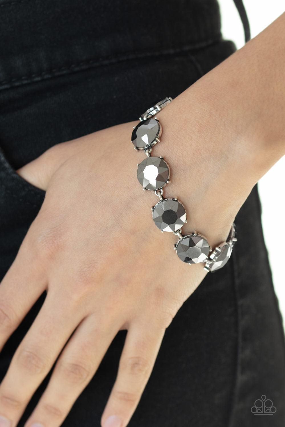 Paparazzi Accessories Fabulously Flashy - Silver Nestled inside classic silver fittings, a collection of oversized hematite rhinestones delicately link around the wrist for a flashy finish. Features an adjustable clasp closure. Sold as one individual brac