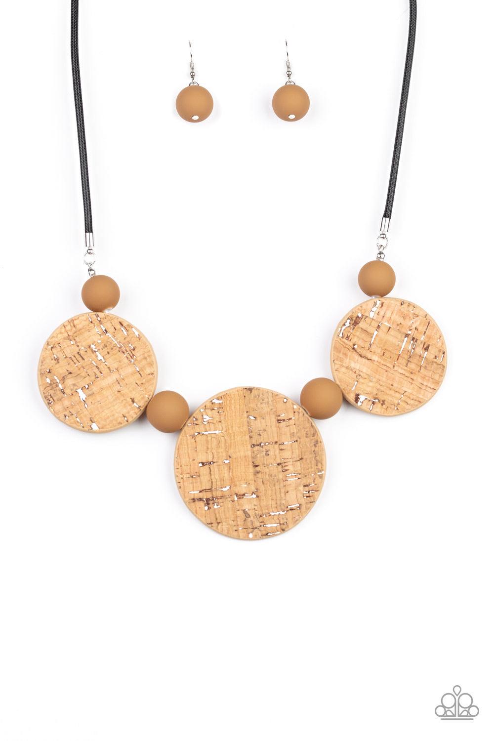 Paparazzi Accessories Pop The Cork - White Featuring white accents, cork-like frames and brown matte beads are threaded along an invisible wire below the collar for a statement-making look. Features an adjustable clasp closure. Sold as one individual neck