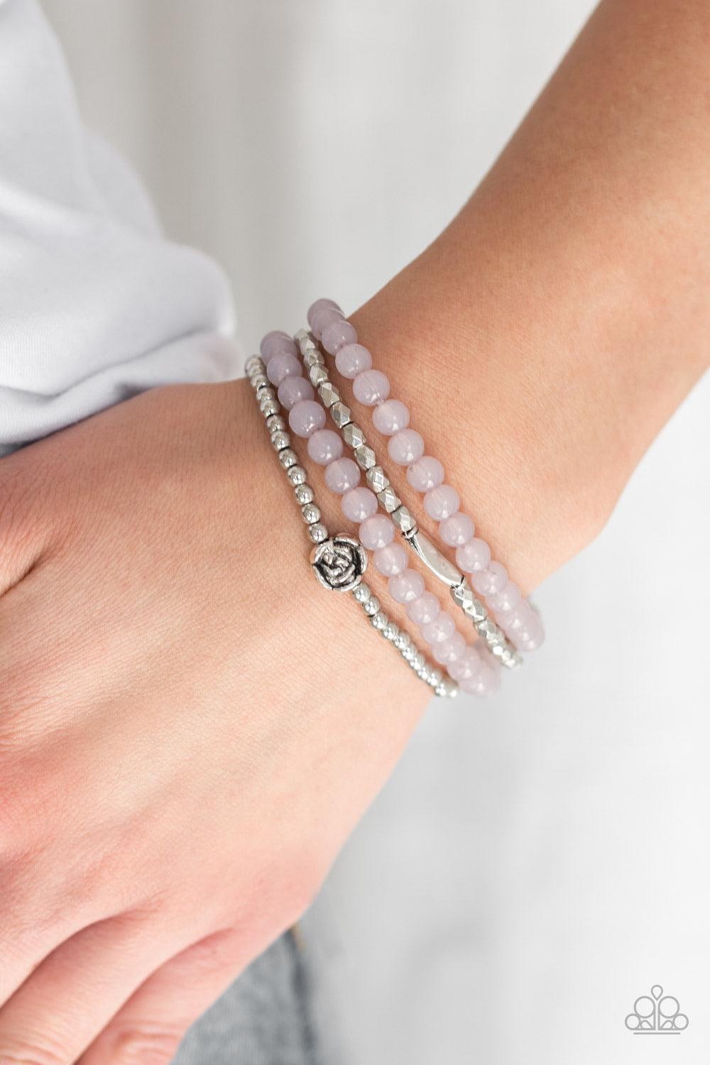 Paparazzi Accessories Blooming Buttercups - Silver Mismatched silver beads and strands of glassy gray beads are threaded along stretchy bands. Infused with silver accents, dainty rose blossoms adorn the wrist for a seasonal finish. Jewelry