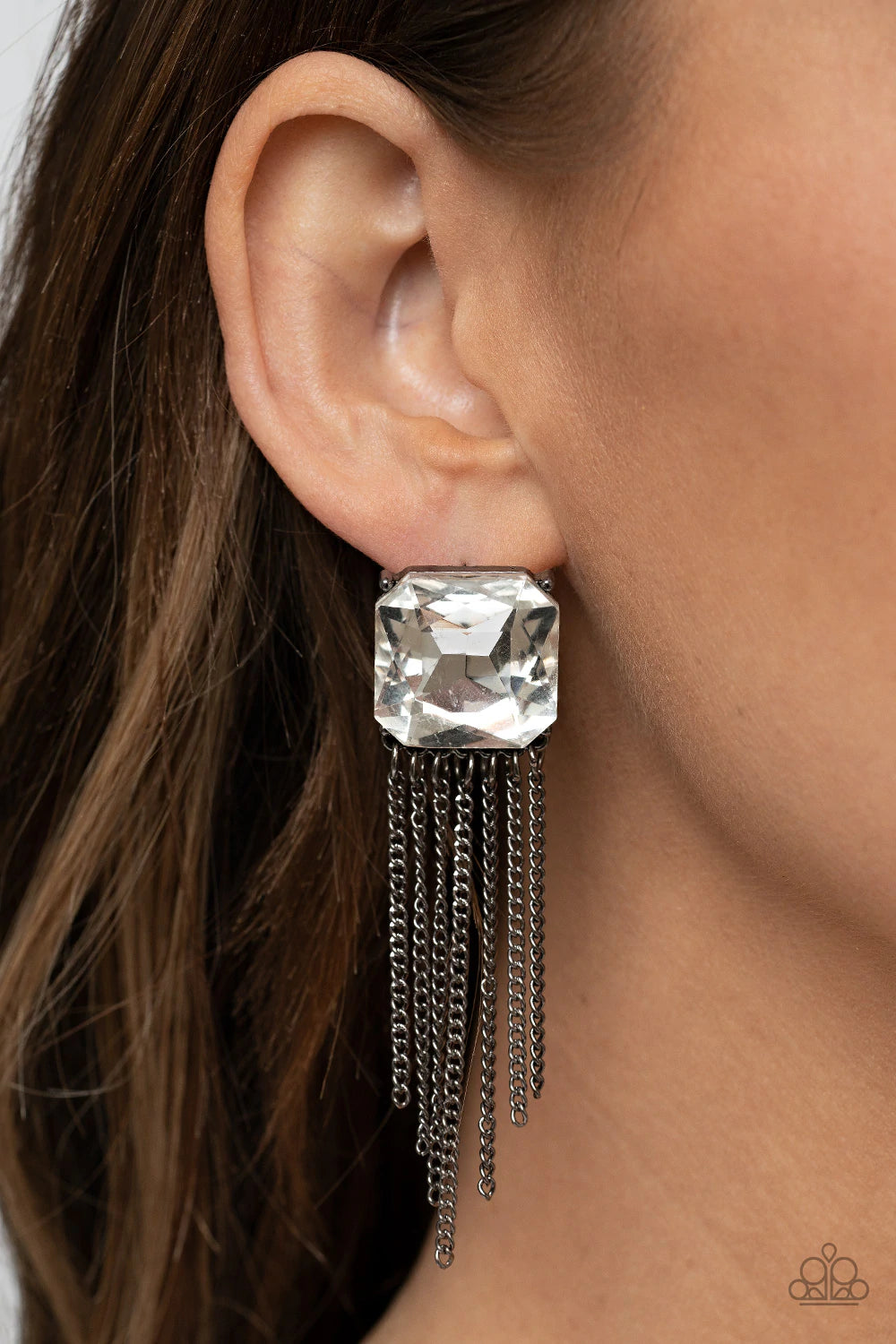 Paparazzi Accessories Supernova Novelty - Black An oversized radiant cut white gem is pressed into a pronged gunmetal fitting that gives way to a tapered curtain of gunmetal chains, resulting in an out-of-this-world sparkle. Earring attaches to a standard