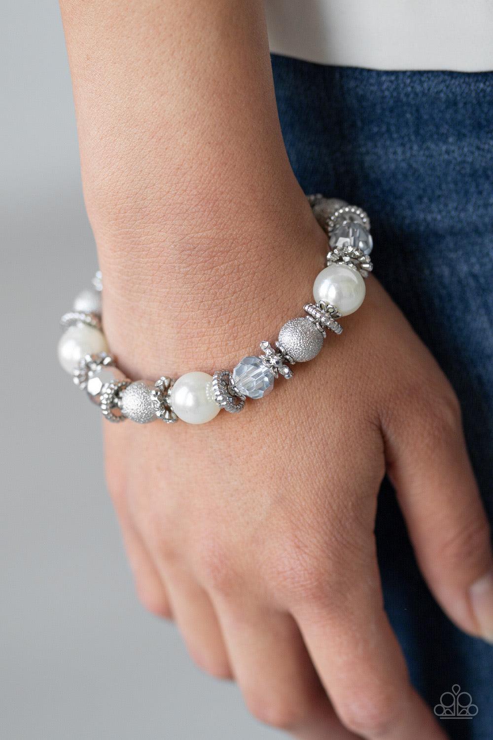 Paparazzi Accessories Sparking Conversation - White A sparkling collision of pearly white beads, shimmery silver accents, faceted metallic crystals, and white rhinestone encrusted rings are threaded along a stretchy band around the wrist for a refined fla