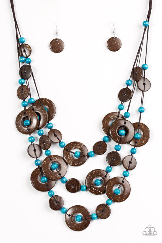 Paparazzi Accessories Bahama Bungalow - Blue Brushed in a distressed finish, wooden discs link into three summery rows below the collar. Round blue beads are knotted between the wooden accents, adding colorful accents to the seasonal palette. Features a b