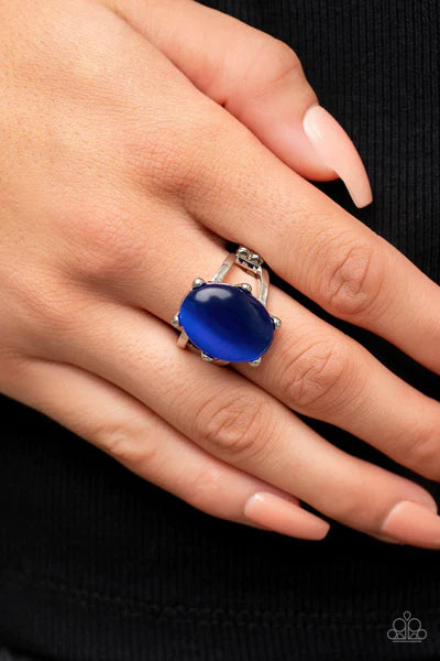 Paparazzi Accessories Enchantingly Everglades - Blue An oval blue cat's eye gemstone sits atop a pronged silver frame along two layered silver bands, resulting in an enchanting centerpiece atop the finger. Features a stretchy band for a flexible fit. Sold