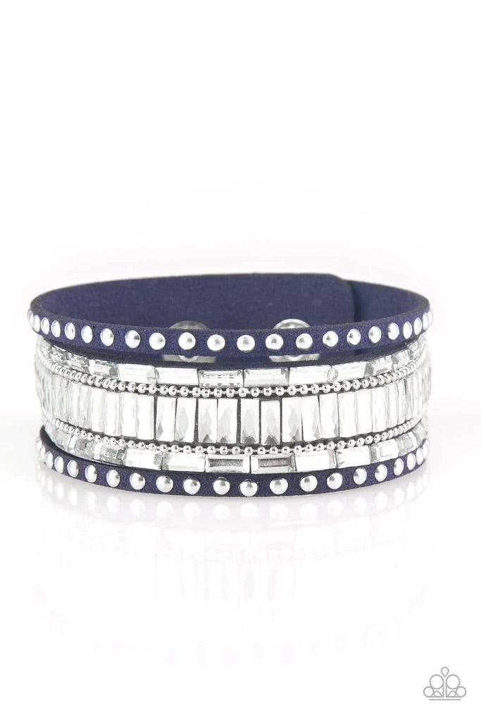 Paparazzi Accessories Rock Star Rocker - Blue Shiny silver studs, dainty silver ball chains, and edgy white emerald-cut rhinestones race along a spliced blue suede band for a rock star look. Features an adjustable snap closure. Sold as one individual brac