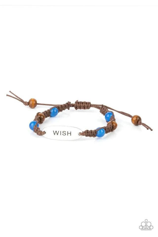 Paparazzi Accessories WISH This Way - Blue An oval silver plate engraved with the word "WISH" creates a warmhearted medallion as it connects to brown cording interwoven with wooden and glossy blue beads for a harmonious vibe around the wrist. Features an