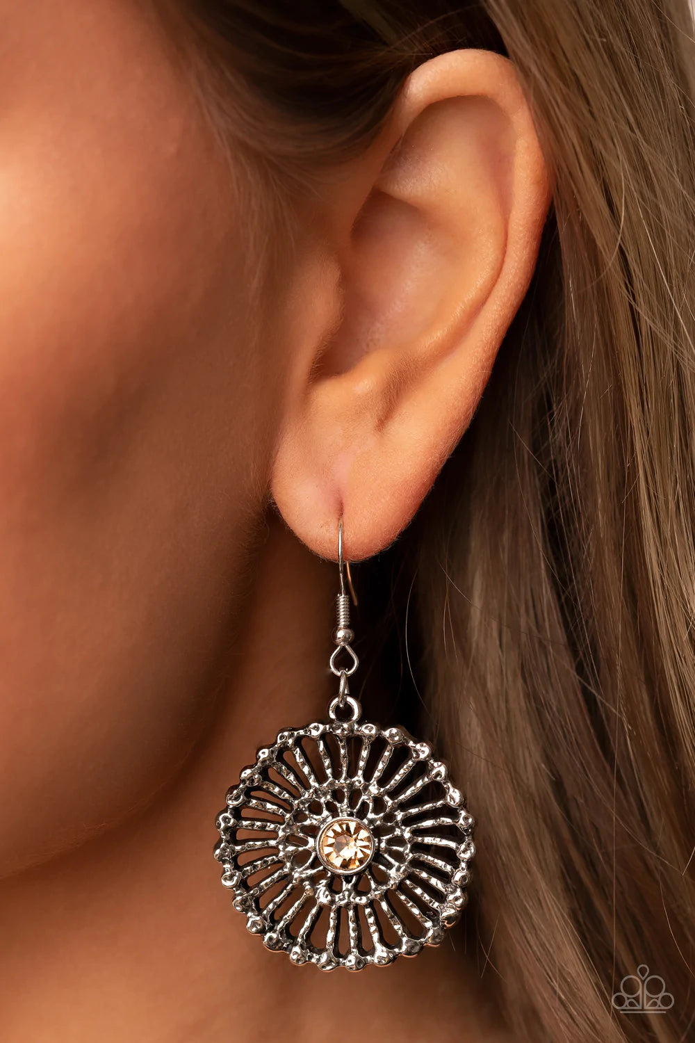 Paparazzi Accessories Tangible Twinkle - Brown Hammered silver spokes flare out from a golden topaz rhinestone center, resulting in a studded silver frame. Earring attaches to a standard fishhook fitting. Sold as one pair of earrings. Earrings