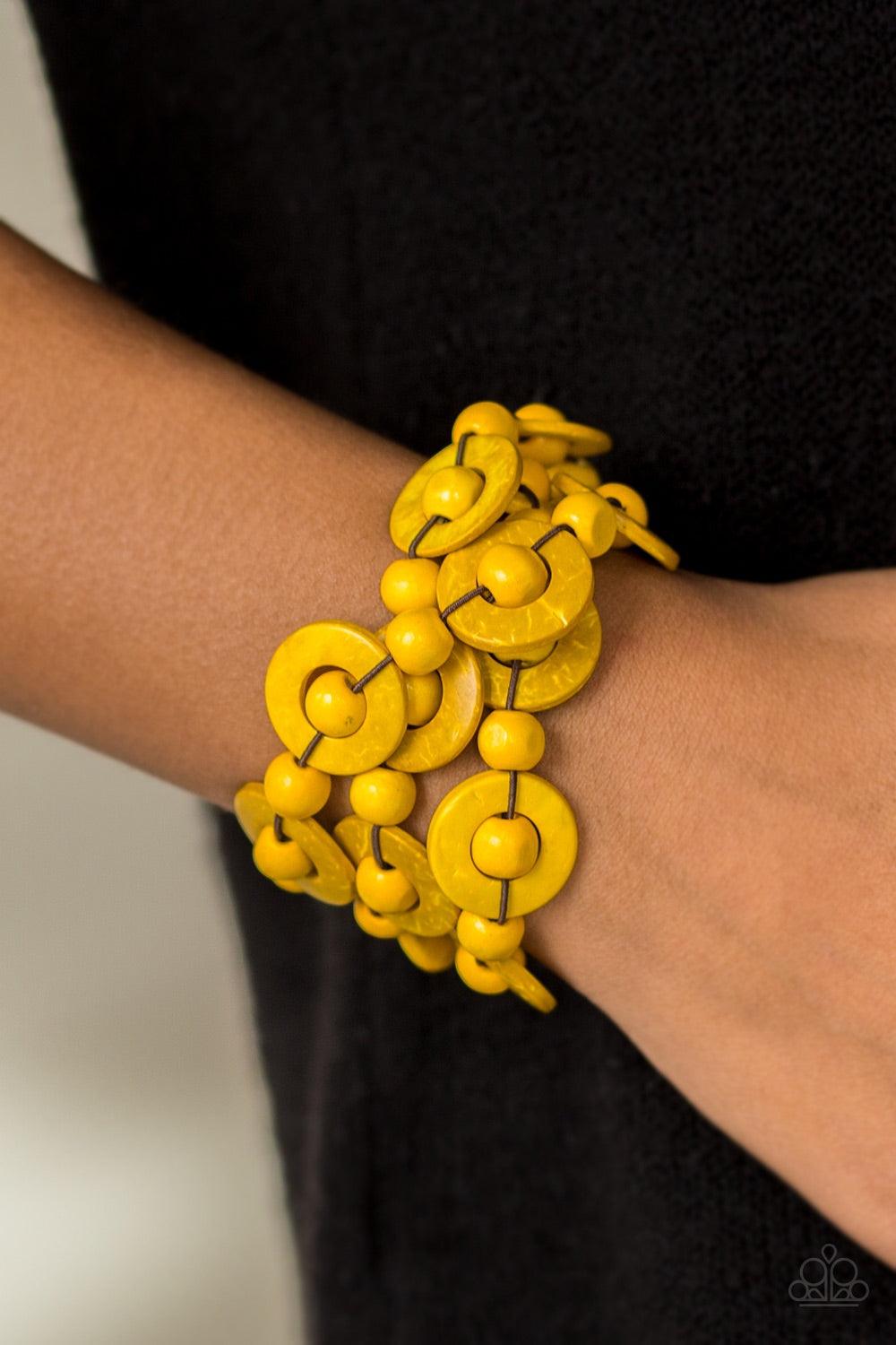 Paparazzi Accessories Cancun Catch ~Yellow Brushed in sunny yellow finishes, wooden rings and beads are knotted in place along three stretchy strands, creating summery layers around the wrist. Features a button loop closure.