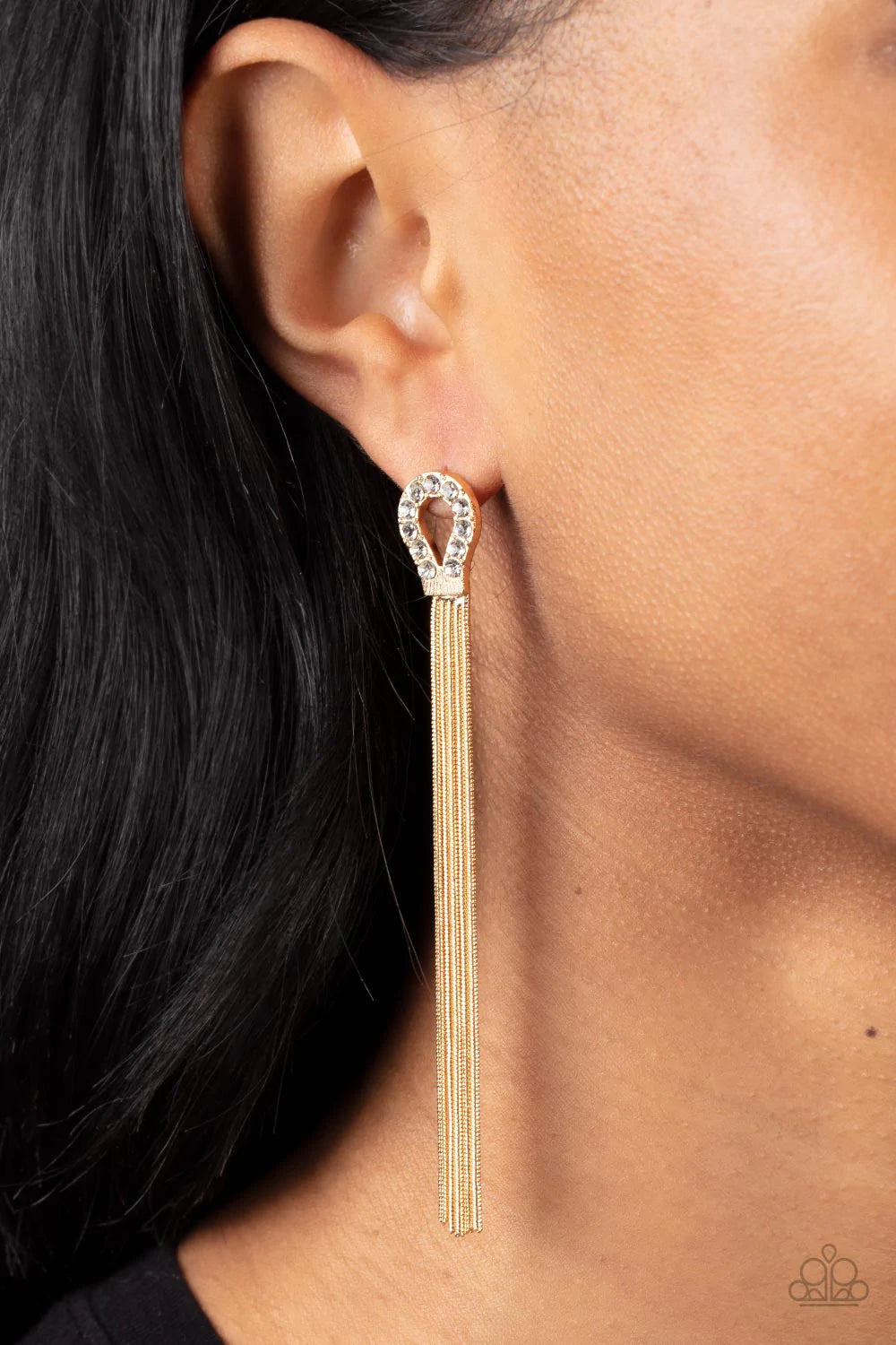 Paparazzi Accessories Dallas Debutante - Gold A glistening curtain of round gold snake chains stream out from the bottom of a dainty horseshoe frame adorned in glassy white rhinestones, creating a tantalizing tassel. Earring attaches to a standard post fi