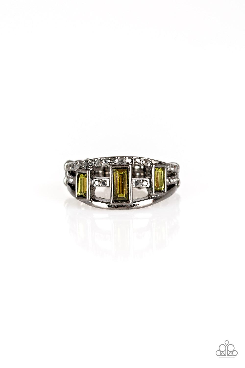 Paparazzi Accessories Noble Nova - Green Three green emerald-cut rhinestones are encrusted along three gunmetal bands radiating with smooth surfaces and sections of glittery hematite rhinestones for an edgy fashion. Features a stretchy band for a flexible