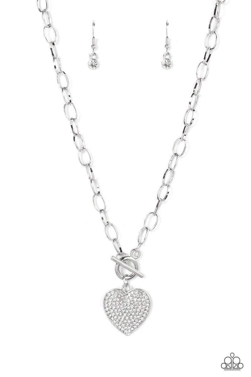 Paparazzi Accessories If You LUST - White A white rhinestone dotted silver heart frame sparkles from a toggle closure at the center of an oval silver linked chain for a flirtatious fashion. Features a toggle closure. Sold as one individual necklace. Inclu