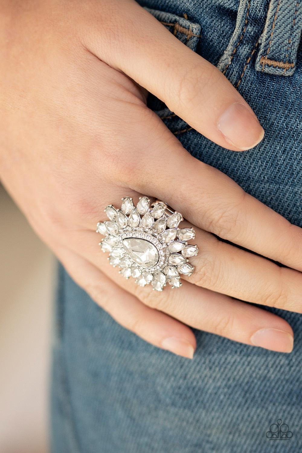 Paparazzi Accessories Who’s Counting ~White White teardrop petals fan out from a dramatically oversized white teardrop rhinestone center, stacking into a glamorous centerpiece atop the finger. Features a stretchy band for a flexible fit. Sold as one indiv