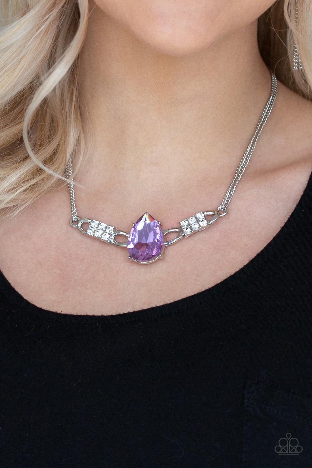 Paparazzi Accessories Way To Make An Entrance - Purple Cut into an alluring teardrop, an oversized purple rhinestone gem attaches to bold silver frames radiating with glassy white rhinestones. The dramatic pendant attaches to doubled silver chains, swingi