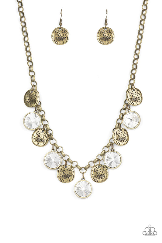 Paparazzi Accessories Spot On Sparkle - Brass A blinding collection of hammered brass discs and oversized white gems swing from the bottom of a bold brass chain, creating noise-making sparkle below the collar. Features an adjustable clasp closure. Sold as