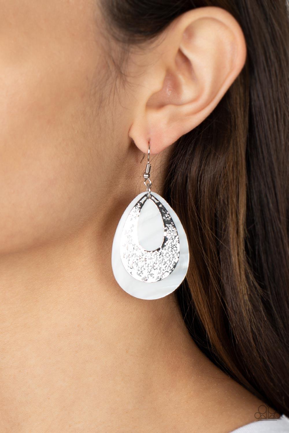 Paparazzi Accessories Bountiful Beaches - White hammered silver teardrop that is stenciled in an abstract pattern delicately overlaps with a white shell-like teardrop, creating a whimsical lure as it swings from the ear. Earring attaches to a standard fis
