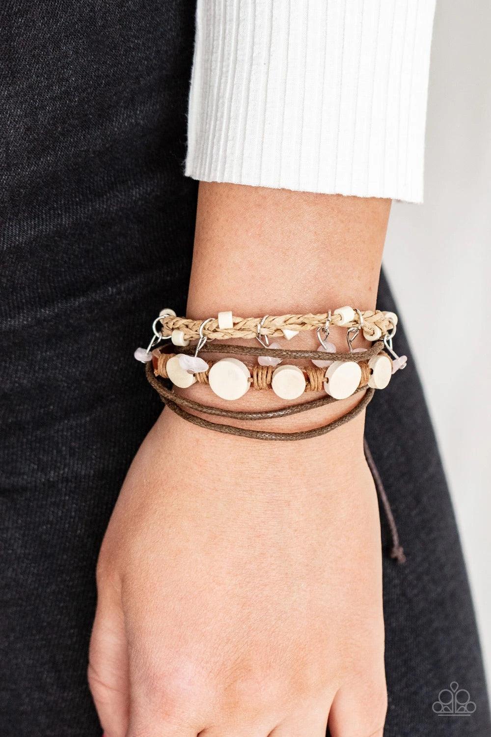 Paparazzi Accessories Run The Rapids - Pink Assorted strands of cording and leather, featuring flat wooden beads and small pink polished stones dangling from silver fittings, layer across the wrist for an earthy handcrafted style. Features an adjustable s