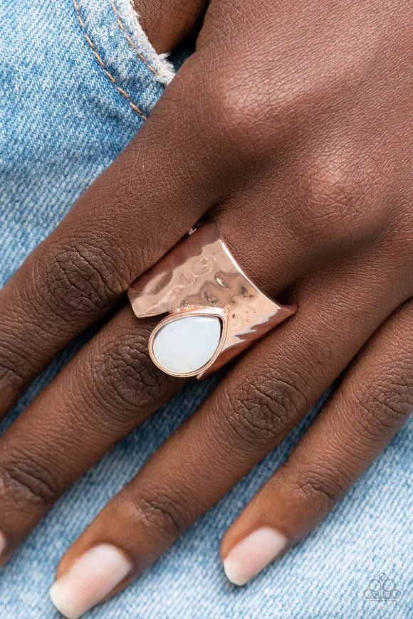 Paparazzi Accessories Optimistically Oracle - Rose Gold A dewy opal teardrop bead is nestled inside the angular cut of a hammered rose gold band, resulting in an ethereal centerpiece atop the finger. Features a stretchy band for a flexible fit. Sold as on