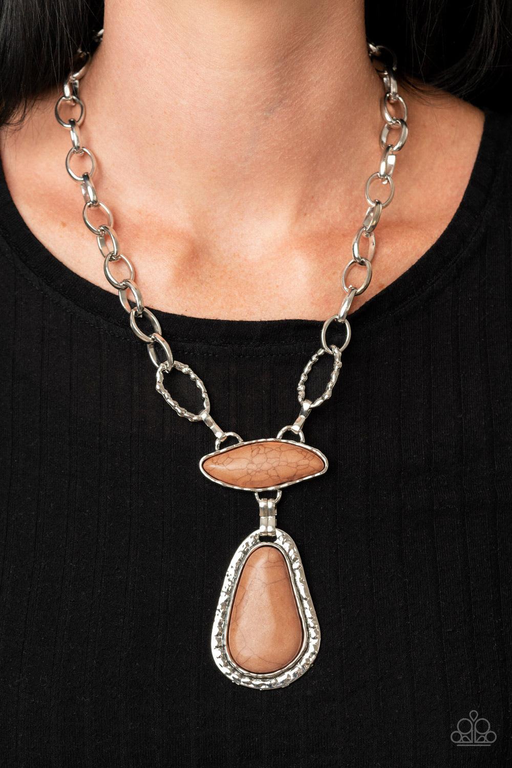 Paparazzi Accessories Rural Rapture - Brown Linked by handcrafted fittings, a pair of imperfect brown stones are pressed into asymmetrical hammered silver frames as they stack below the collar. Oversized silver links and a pair of hammered links form into