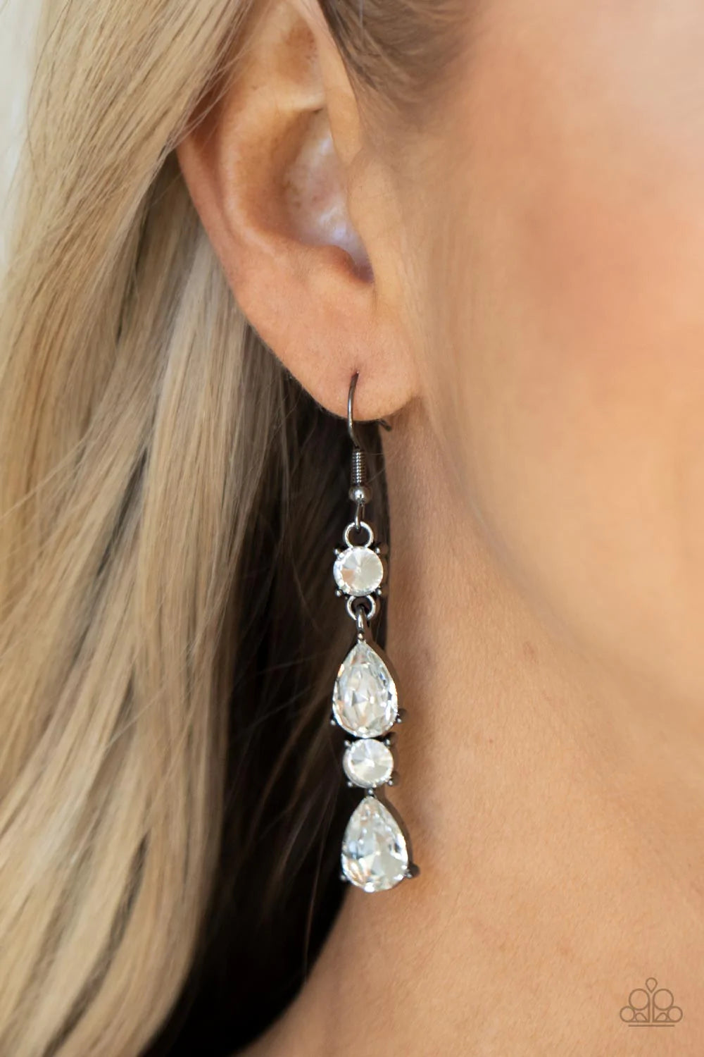 Paparazzi Accessories Raise Your Glass to Glamorous - Black A glamorous collection of brilliant white teardrop and round rhinestones encased in classic gunmetal pronged fittings stack together creating an irresistibly refined lure. Earring attaches to a s