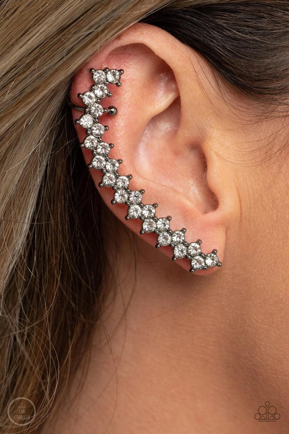 Paparazzi Accessories Let There Be LIGHTNING - Black Encased in studded gunmetal fittings, pairs of glassy white rhinestones stack into a zigzagging frame up the ear for an electrifying fashion. Features a dainty cuff attached to the top for a secure fit.