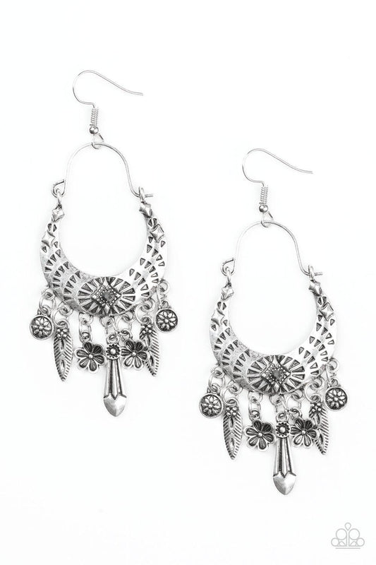 Paparazzi Accessories Nature Escape ~Silver Stamped in triangular textures, a shimmery silver crescent frame gives way to a fringe featuring glistening floral and abstract charms. Suspended by a dainty wire fitting, the tribal inspired frame is dotted wit