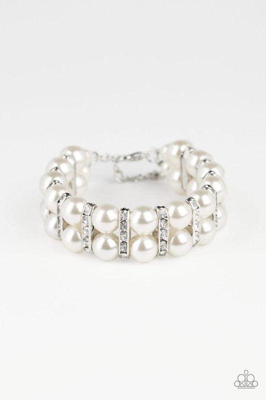 Paparazzi Accessories Glowing Glam - White Pairs of pearly white beads and white rhinestone encrusted silver fittings are threaded along an invisible wire around the wrist for a refined flair. Features an adjustable clasp closure. Sold as one individual b