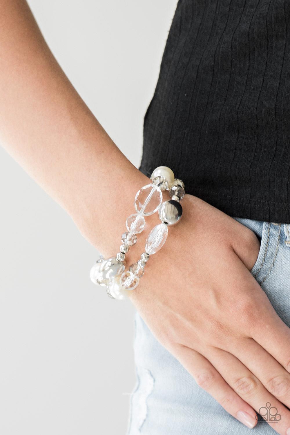 Paparazzi Accessories Downtown Dazzle - White An array of white pearls, shiny silver beads, and white crystal-like beads are threaded along stretchy bands around the wrist for a refined look. Jewelry