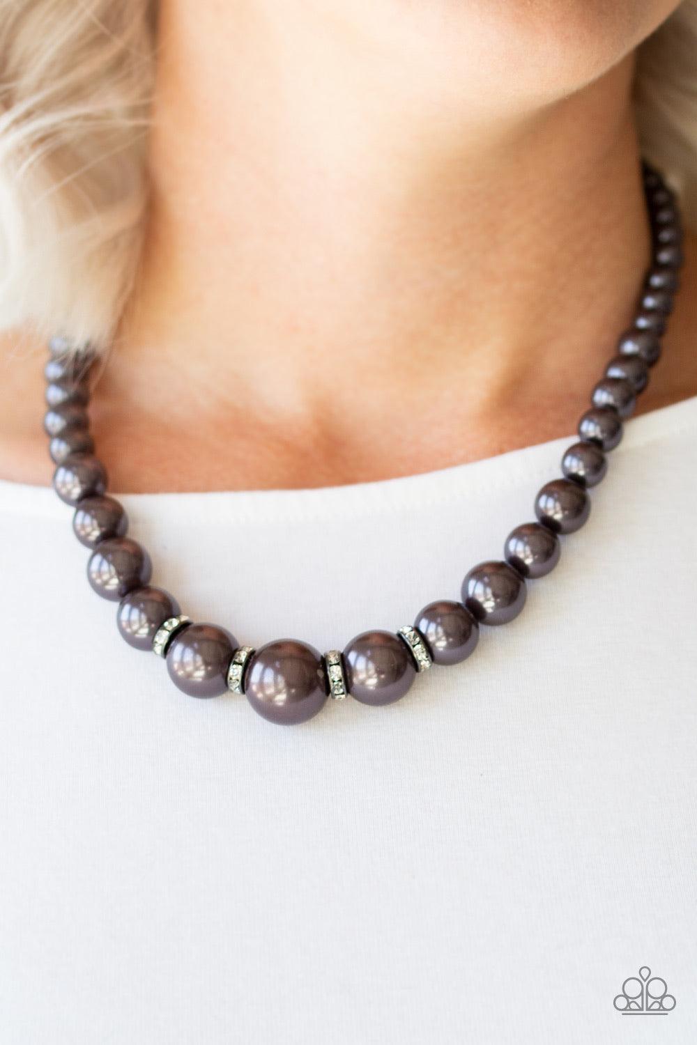 Paparazzi Accessories Party Pearls - Black Gradually increasing in size, pearly gunmetal beads trickle below the collar for a classic look. Encrusted in dazzling white rhinestones, glittery rings are sprinkled between the pearls for a timeless finish. Fea