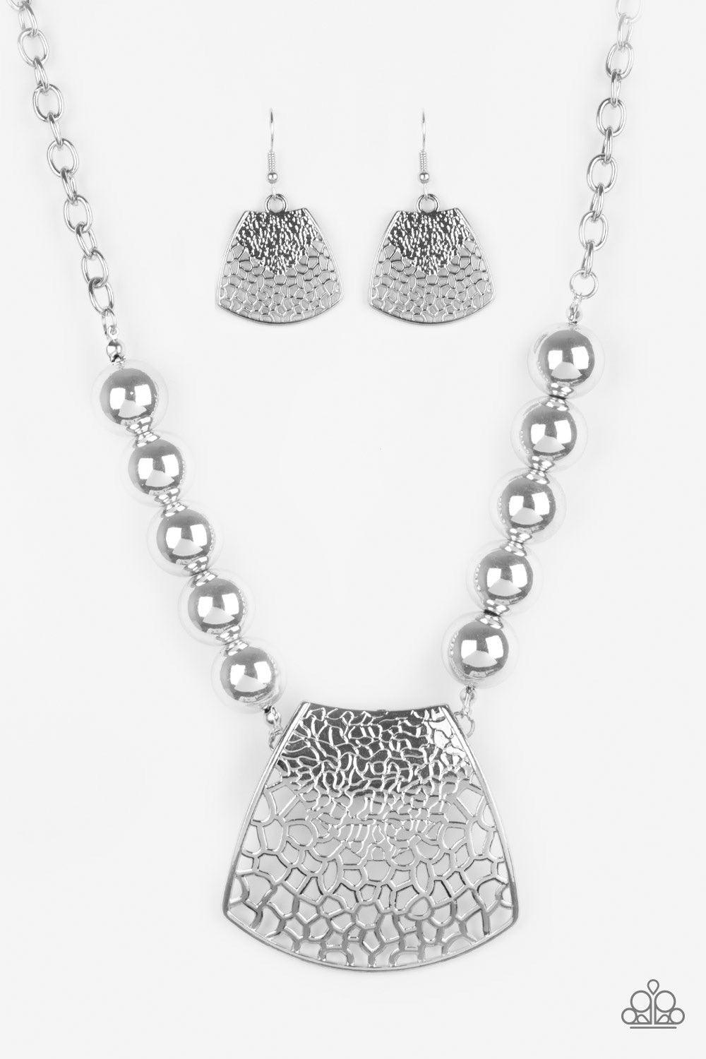 Paparazzi Accessories Large And In Charge - Silver Featuring ornately stenciled and embossed details, a flared silver plate swings from a boldly silver beaded chain below the collar for a fierce look. Features an adjustable clasp closure. Jewelry
