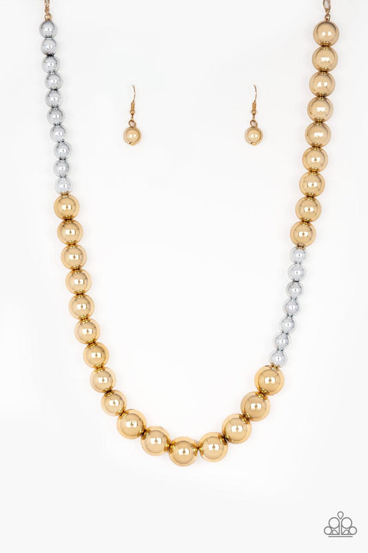 Paparazzi Accessories Power To The People - Gold Varying in size, glistening gold and shimmery silver beads drape below the collar in a dramatically asymmetrical fashion. Features an adjustable clasp closure. Jewelry