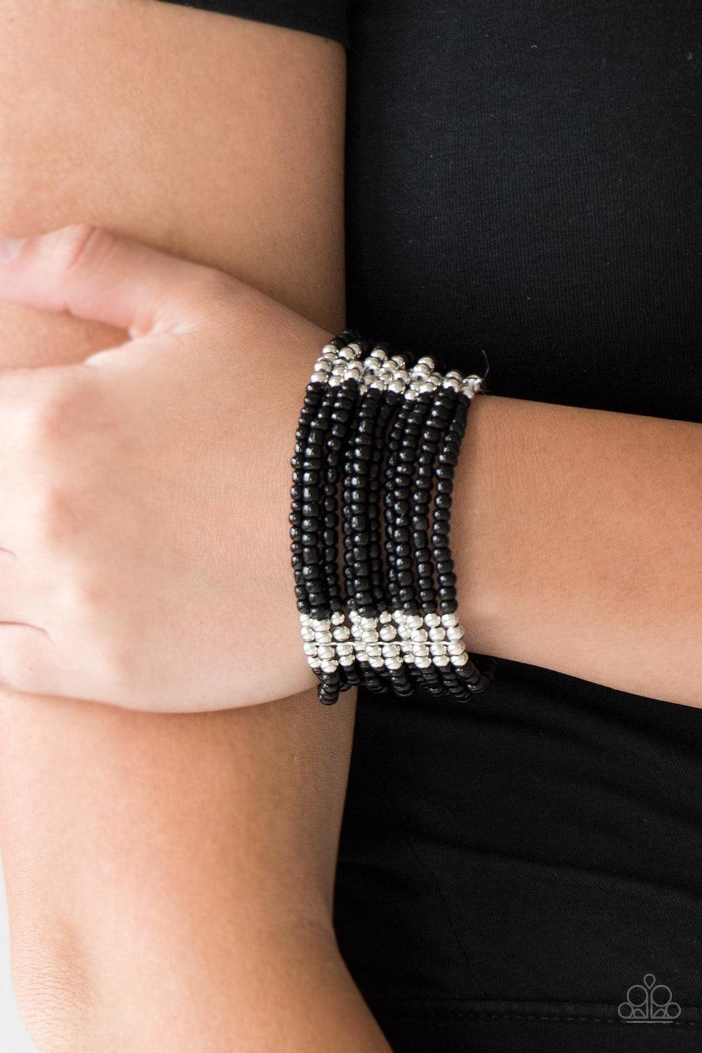 Paparazzi Accessories Outback Odyssey - Black Joined together with metallic fittings, countless black seed beads are threaded along stretchy elastic bands. Sections of dainty silver beads are sprinkled along the colorful layers, adding hints of shimmer to