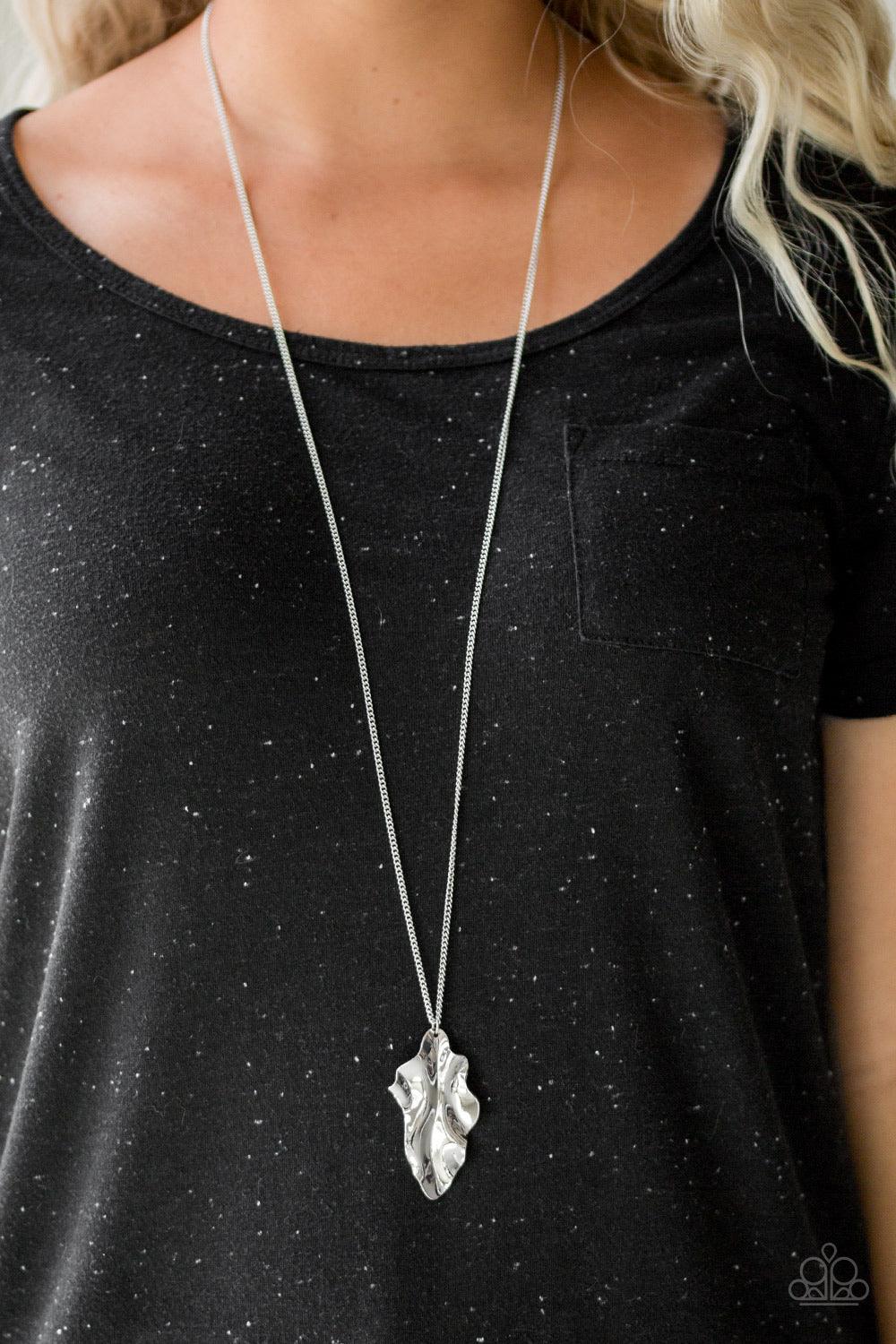 Paparazzi Accessories Fiercely Fall - Silver An elongated silver chain gives way to a rippling silver leaf-like pendant for a seasonal look. Features an adjustable clasp closure. Sold as one individual necklace. Includes one pair of matching earrings. Hos