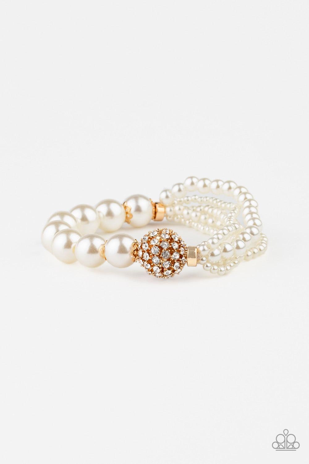 Paparazzi Accessories Vintage Collision - Gold Featuring stretchy bands, a white rhinestone encrusted gold bead joins together strands of mismatched pearls and a single strand of classic white pearls around the wrist for a timeless twist. Jewelry