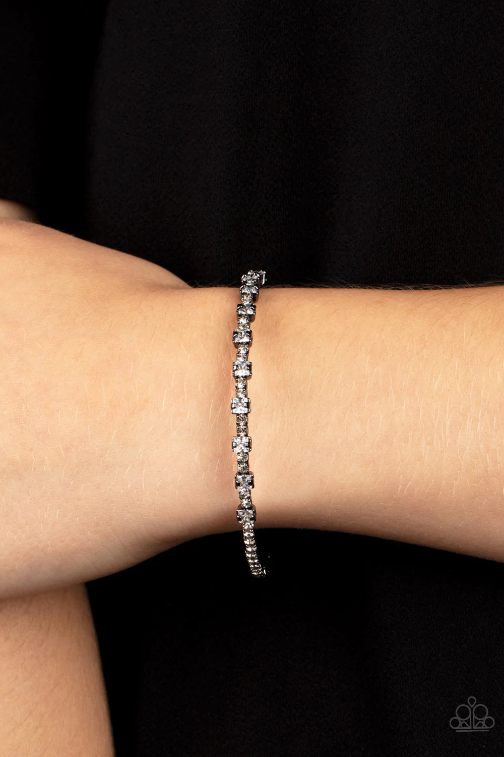Paparazzi Accessories Timelessly Tiny - Black Featuring sleek gunmetal fittings, a classic band of dainty white rhinestones is interrupted with square cut white rhinestones, adding a timeless twist to the stackable cuff. Sold as one individual bracelet. B